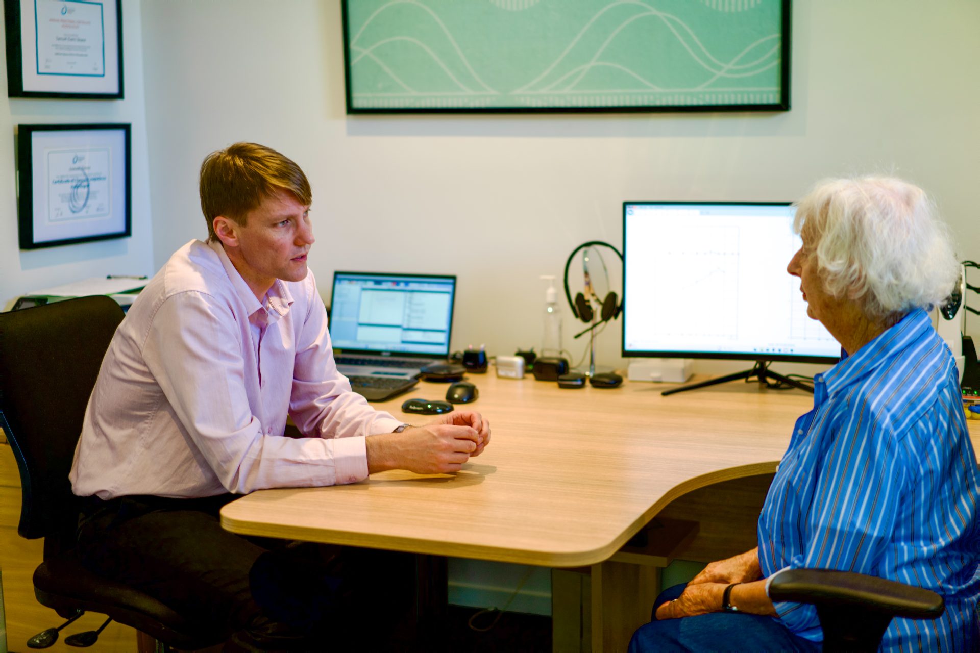 Hearing specialist discussing hearing assessment with an older patient