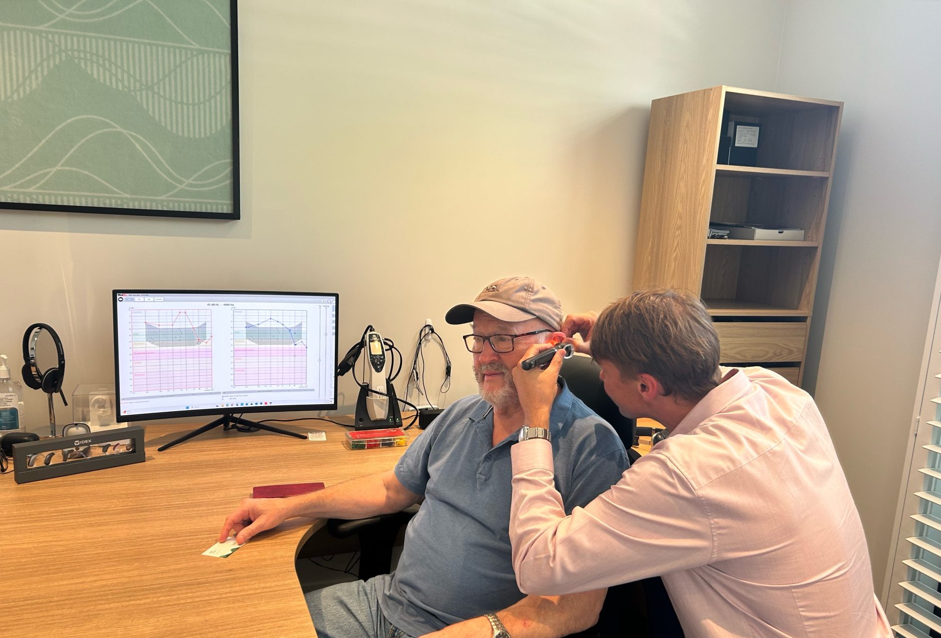 Audiologist Sam Sloane performing an otoscopic ear canal examination for a patient.