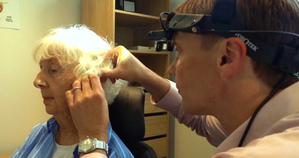 Hearing specialist performing professional ear wax removal
